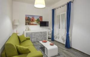 een woonkamer met een groene bank en een tv bij Awesome Apartment In Comiso With Kitchen in Comiso