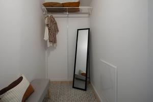 a mirror in a room with a couch and a shelf at Cozy apartment 2 stops-15 mins away from city center in Stockholm