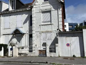 een oud wit bakstenen huis met een poort bij Studio Berck-Plage, 1 pièce, 2 personnes - FR-1-646-50 in Berck-sur-Mer