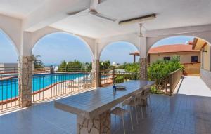 eine große Terrasse mit Tisch und Swimmingpool in der Unterkunft Nice Home In Marina Di Ragusa in Marina di Ragusa