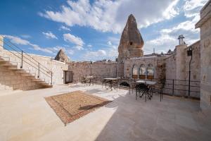 einen Innenhof eines Steingebäudes mit Tischen und Stühlen in der Unterkunft Ares Cave Suites in Goreme