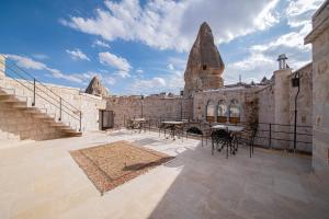a courtyard of a stone building with tables and chairs at Ares Cave Suites in Goreme