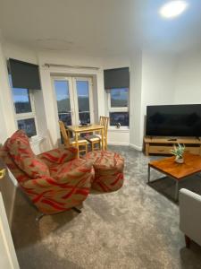 a living room with a chair and a television at Duloch Bridge View in Dunfermline