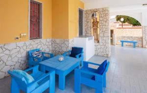 een blauwe tafel en stoelen in een kamer bij Cozy Home In Marina Di Ragusa With Kitchenette in Marina di Ragusa