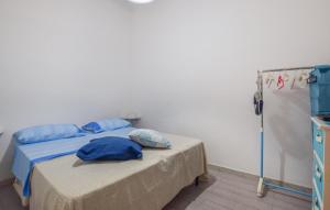 a bedroom with a bed with blue pillows on it at Cozy Apartment In Mondello With Wifi in Mondello