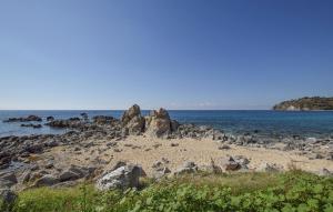 einen Strand mit einigen Felsen und dem Meer in der Unterkunft Lovely Apartment In Marina Di Ragusa in Marina di Ragusa