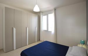 Un dormitorio con una cama azul y una ventana en Nice Apartment In Marina Di Ragusa With Kitchenette, en Marina di Ragusa