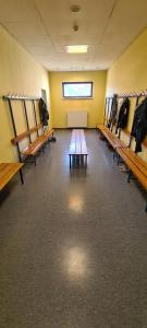 a dressing room with wooden benches and a table at INDOOR Camping Sportzentrum Zeltweg in Zeltweg