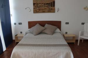 a bedroom with a bed with two pillows on it at Apartamentos turísticos Vistademar in Luarca