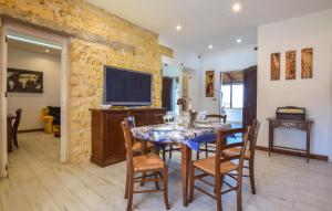 a dining room with a table with chairs and a tv at Pet Friendly Home In Palermo With Kitchen in Palermo