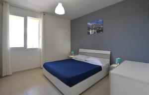 ein Schlafzimmer mit einem Bett mit einer blauen Decke in der Unterkunft Cozy Apartment In Marina Di Ragusa in Marina di Ragusa
