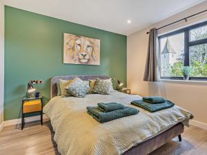 a bedroom with a large bed with green walls at 2 Bed in Heyope 94203 in Knighton