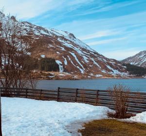 a fence next to a body of water with a mountain at Liten leilighet med to soverom in Valberg +24 photos