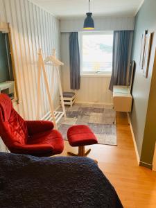 a room with a bed and a chair and a window at Liten leilighet med to soverom in Valberg