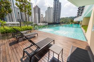 - une terrasse avec bancs et une piscine dans un bâtiment dans l'établissement Inspirasi Mont Kiara 3 Bedroom, à Kuala Lumpur
