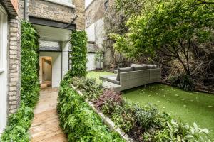 a garden with a couch in the back of a building at Luxury 2 Bedrooms Apartment in South Kensington in London