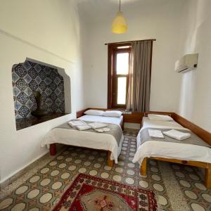 a room with three beds and a window at Held Hotel in Antalya