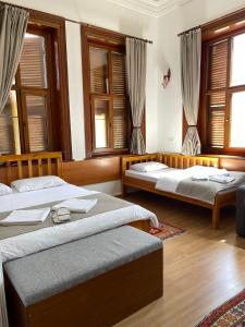 a bedroom with two beds and windows with curtains at Held Hotel in Antalya