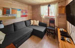 a living room with a gray couch in a cabin at 6 Bedroom Lovely Home In Treungen in Fjone +17 photos