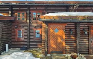a door of a log cabin with snow on it at Nice Home In Vrådal With Kitchen in Vradal