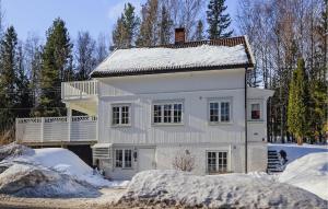 Una casa blanca con nieve encima. en Awesome Home In Noresund With Wifi, en Noresund