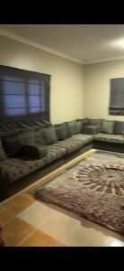 sala de estar con sofá y alfombra en فيلا العزيزيه - الخبر, en Mīnāʼ al ‘Azīzīyah