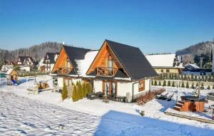 a house in the winter with snow on the ground at Awesome Home In Poronin With Kitchen in Poronin