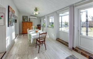 a dining room with a table and chairs and windows at Beautiful Home In Lddekpinge With Kitchen in Löddeköpinge