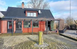 a red house with a black roof at Beautiful Home In Lddekpinge With Kitchen in Löddeköpinge
