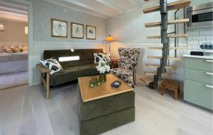 uma sala de estar com um sofá e uma cadeira em Amazing Home In ngelholm With Kitchen em Ängelholm