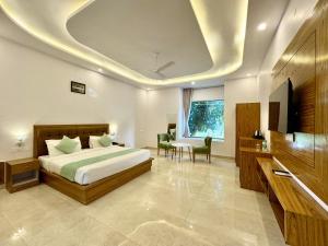 1 dormitorio con 1 cama, mesa y sillas en The White Oak Corbett Spa & Resort en Rāmnagar