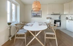 Il comprend une cuisine et une salle à manger avec une table et des chaises blanches. dans l'établissement Gorgeous Home In Torekov With Sauna, à Torekov