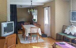3 Bedroom Beautiful Home In Vstervik في فاسترفيك: غرفة معيشة مع طاولة طعام وتلفزيون