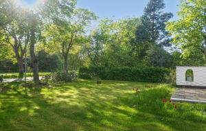 a garden with a small white building in the grass at 3 Bedroom Beautiful Home In Västervik in Västervik