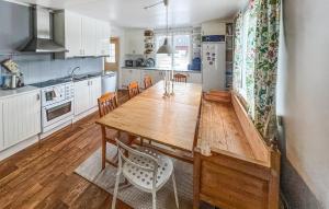 a kitchen with a wooden table and chairs at Cozy Home In Nrkesberg With Outdoor Swimming Pool in Närkesberg
