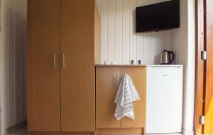 a kitchen with a refrigerator and a tv on the wall at Pet Friendly Home In Miedzyzdroje With Kitchen in Międzyzdroje