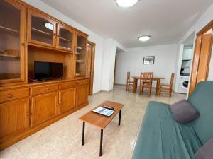 a living room with a couch and a table at Apartamentos Estacion Oropesa 3000 in Oropesa del Mar