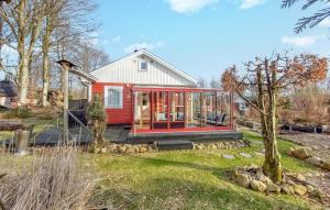OrkelljungaにあるCozy Home In rkelljunga With Wifiの庭のガラス戸付赤い家