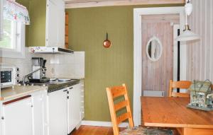 eine Küche mit einem Holztisch und eine Küche mit einem Tisch in der Unterkunft Cozy Home In Väse With Wifi in Väse