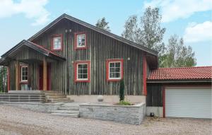 a wooden house with red windows and a garage at 3 Bedroom Amazing Home In rjng in Årjäng