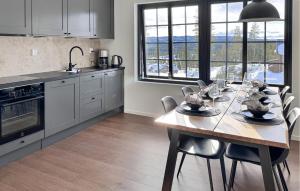 a kitchen with a table with chairs and a dining room at Stunning Apartment In Idre With Sauna in Idre