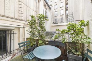a blue table on a balcony with some plants at Caprice Amour in Paris