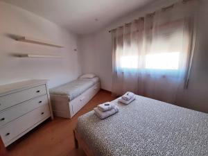 a bedroom with two beds and a dresser and a window at Casa do Vale in Apúlia
