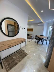 ein Wohnzimmer mit einem Spiegel und einem Tisch in der Unterkunft DARZAYNAH in Monastir