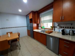 a kitchen with wooden cabinets and a table and a table and a tablektop at Casa do Vale in Apúlia