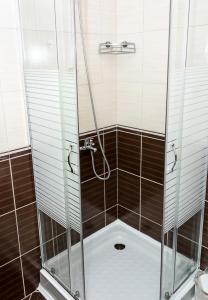 y baño con ducha y puerta de cristal. en New Colorful 1BD Getaway with an Amazing Sea View, en Varna