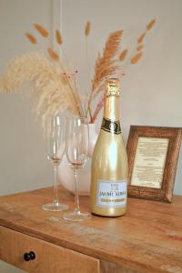 a bottle of champagne and two glasses on a dresser at Het Wapen van Noordwijkerhout in Noordwijkerhout