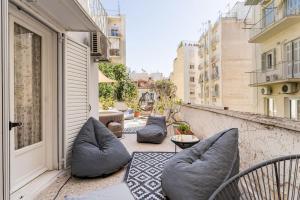an outdoor patio with pillows on a balcony at Amazing 3BDR Apt with Unique Roof Garden in Plaka in Athens