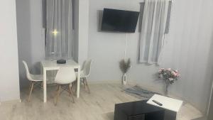 Хотел Враца في Vratsa: غرفة معيشة مع طاولة وطاولة وكراسي بيضاء