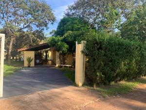 a building with a parking lot with a bush at Chácara Ben te vi in Ribeirão Preto